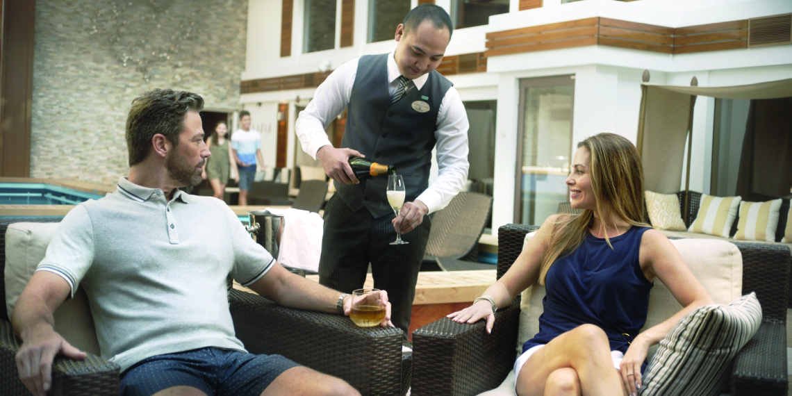 Couple enjoying champagne in The Haven by Norwegian Cruise Line