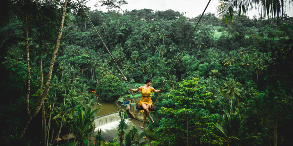 Girl on a swin in the jungle of Bali