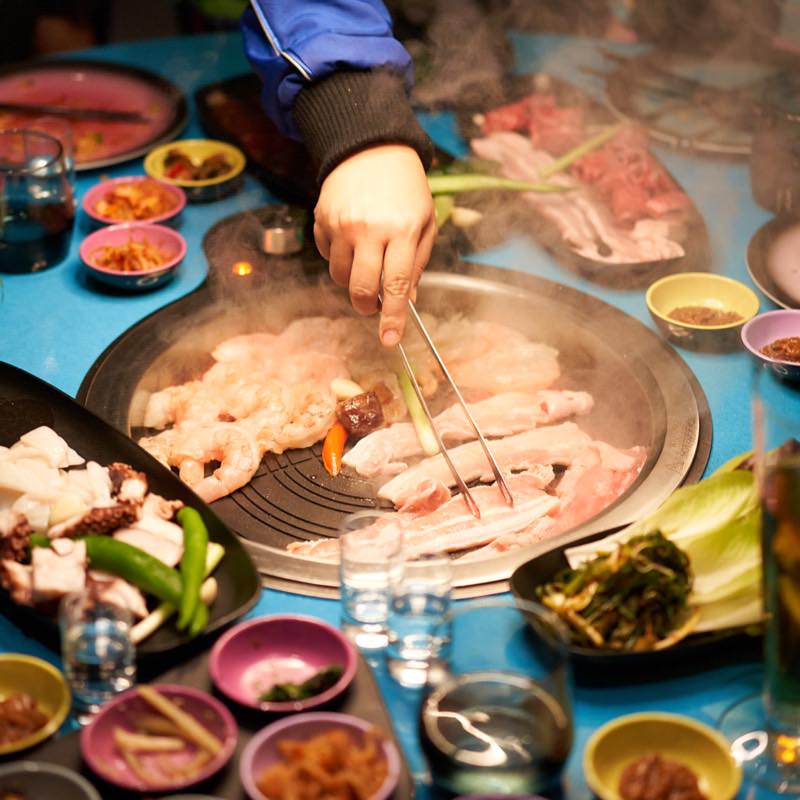 Food on the in-table grill at Gunbae Korean BBQ.